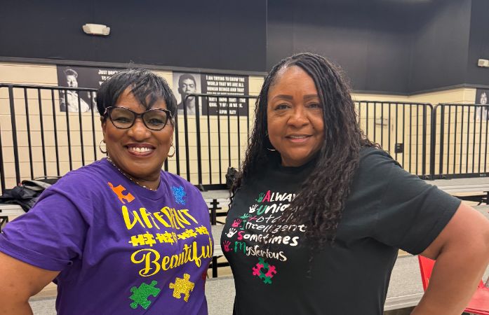  2 teachers smiling with Autism Awareness shirts on