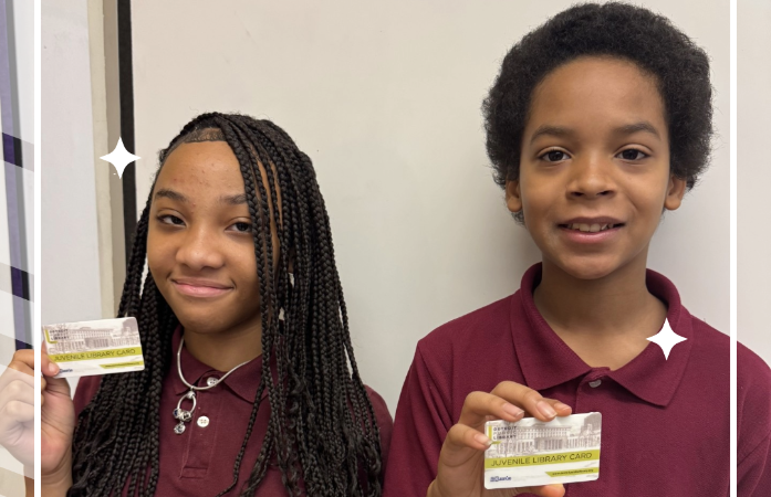  2 students holding up a library card