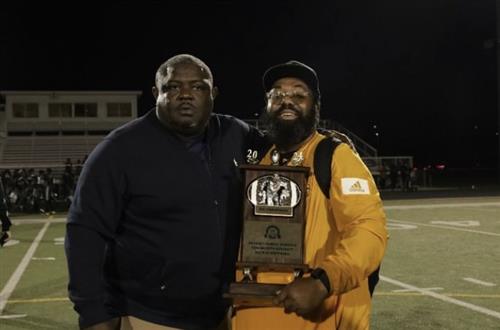 Coach TP and Coach Holmes holding the championship