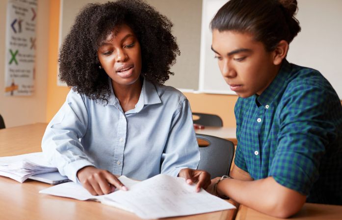  a lady teacher assisting a student with work