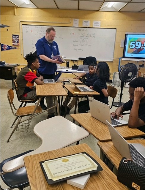  students with teacher at desk