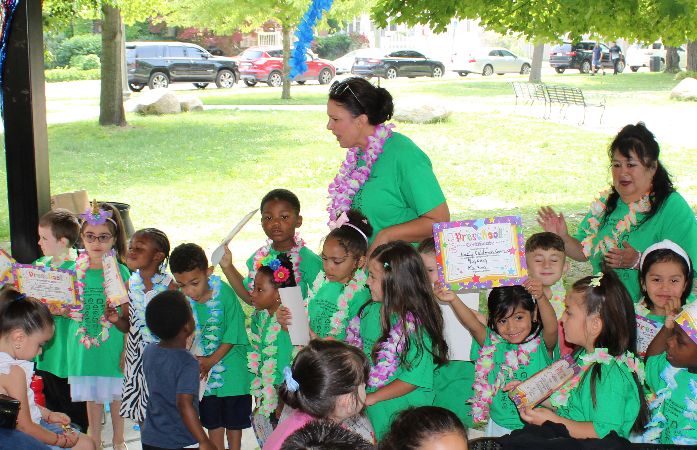  several students wearing green shirt smiling