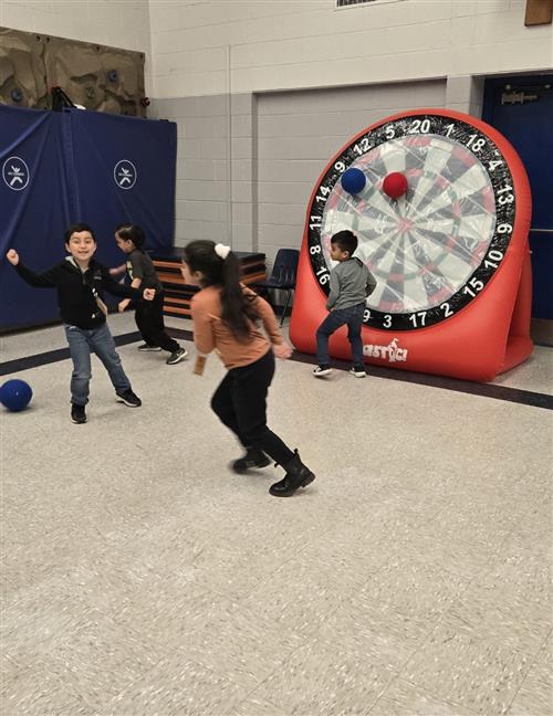 4 kids running around a gym