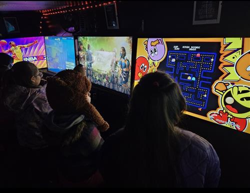kids playing video games on large tv's