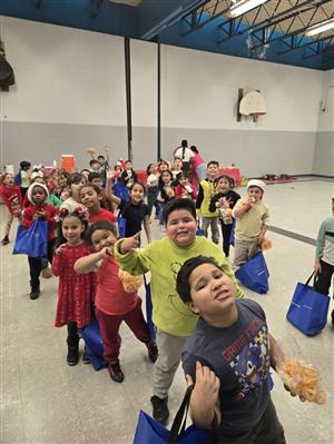 A large group of students holding blue bags posing