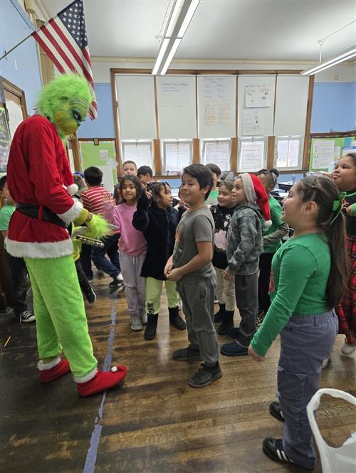 a group of students looking at a green monster character