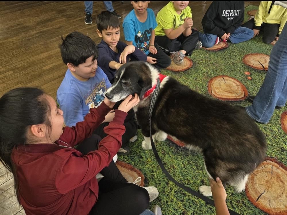  kids sitting on the floor by a dog
