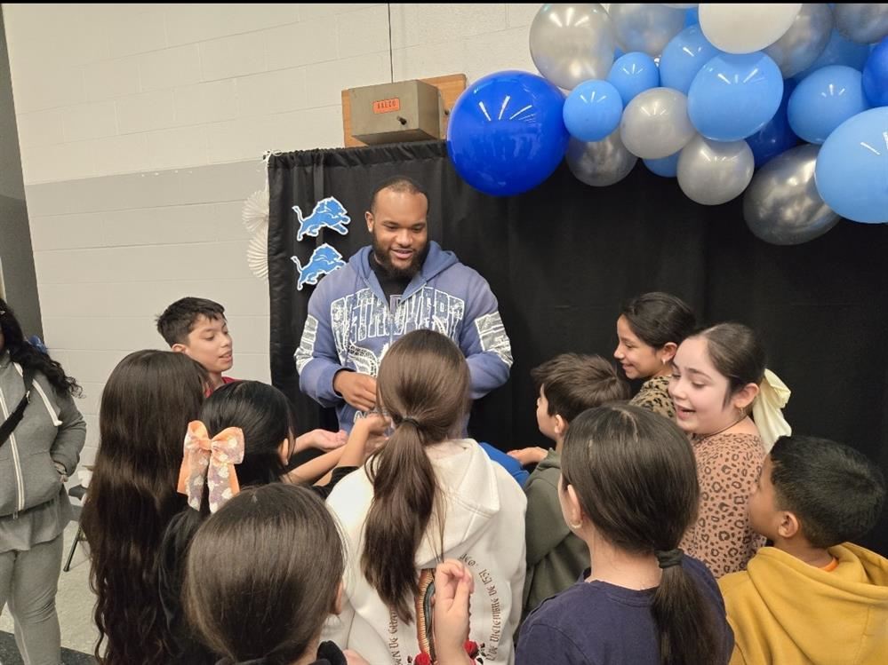  a group of kids standing around a man