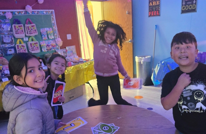  4 kids smiling around a table