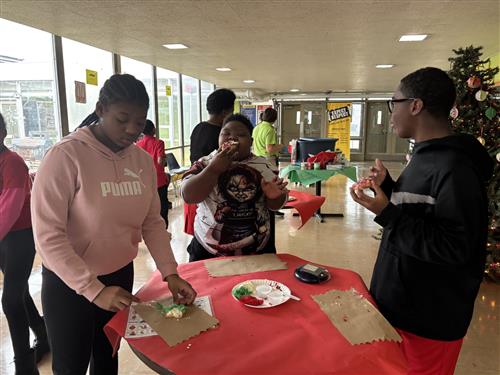Student's decorating Christmas cookies in school hallway