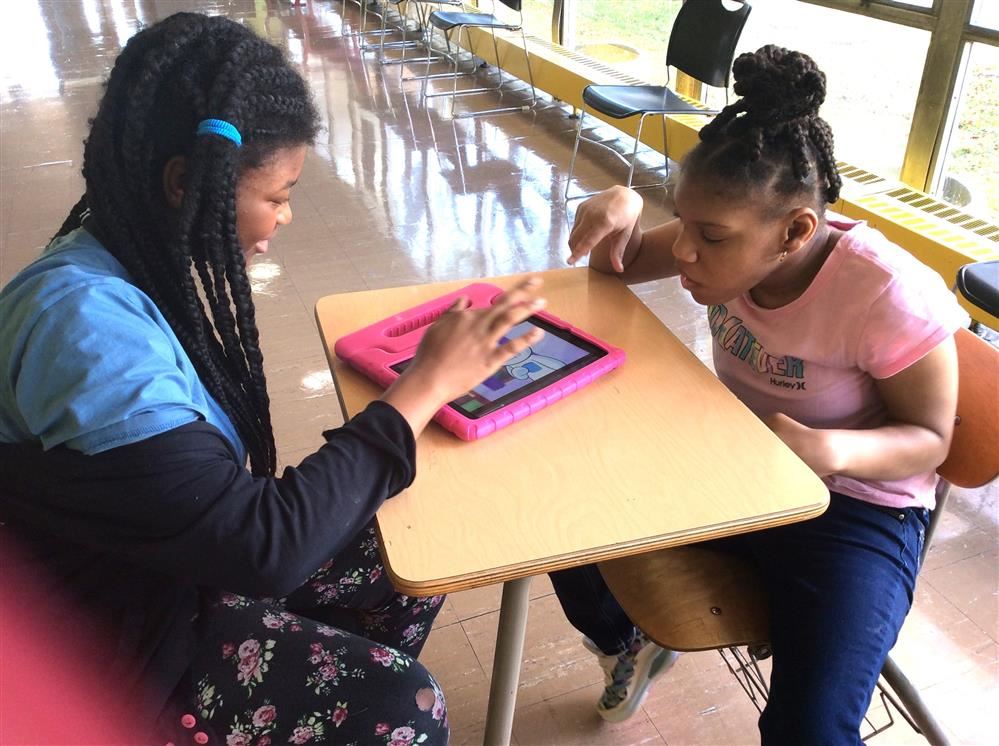  7th Grade student helping 1st Grade peer