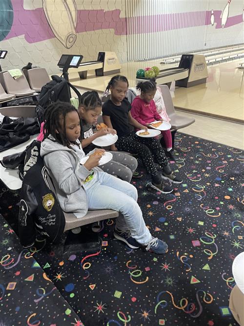 Students eating pizza at Special Olympics Bowling event