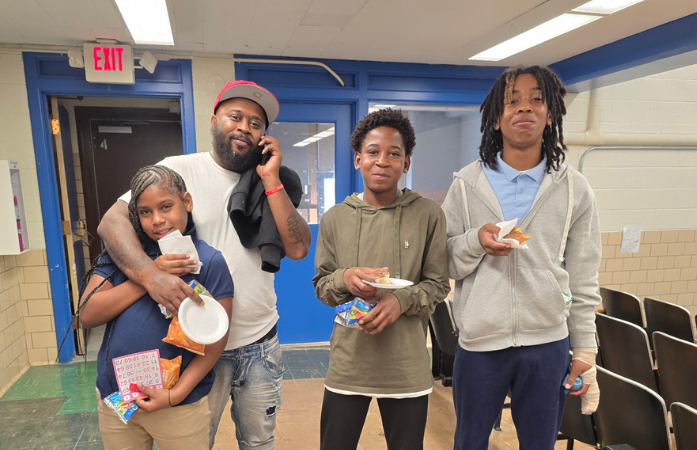  dad smiling with 3 students