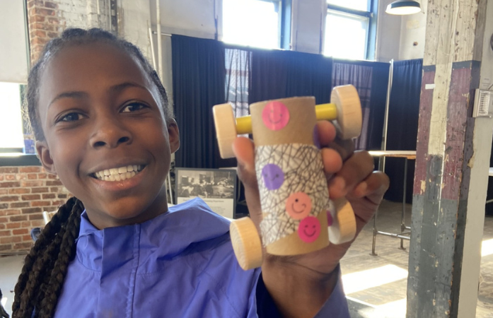  student holding handmade car