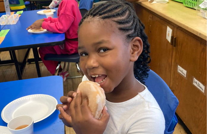 a little girl eating a donut