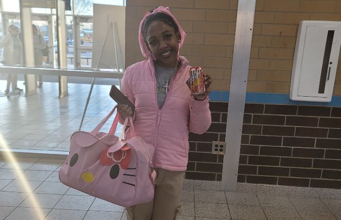  girl in pink holding can