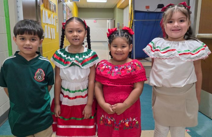  Students smiling and wearing cultural clothing 