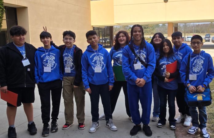 Students standing outside in academic games team shirts