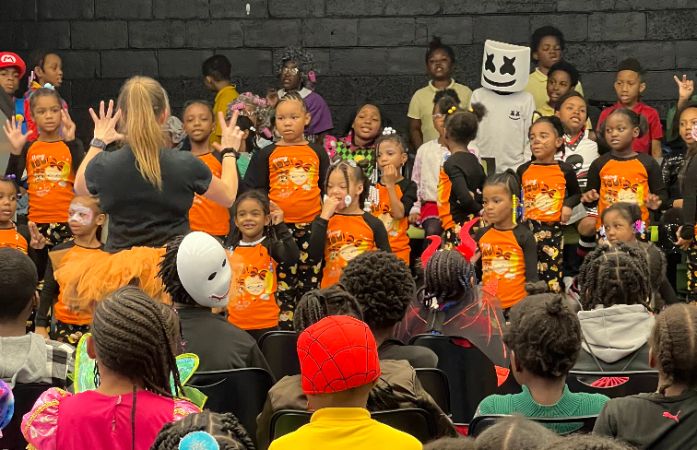 Students on stage singing a Halloween jingle