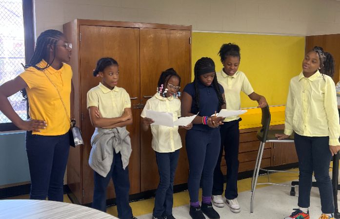  Middel school and elementary group of girls making morning announcements for the school