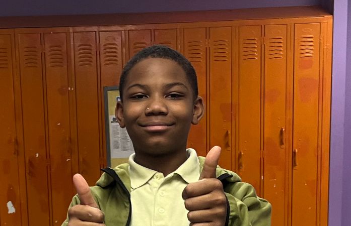 Boy holding up a thumbs up.