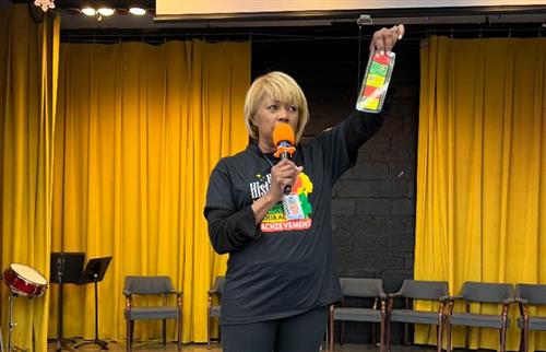 Principal holding up bookmark fo rblack history month