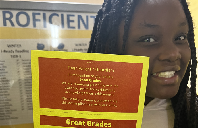  student holding Great Grades McDonald's gift certificate