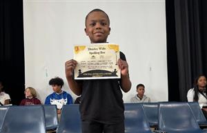 student standing with certificate 