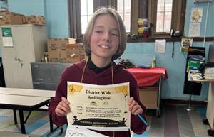 student standing with spelling bee certificate