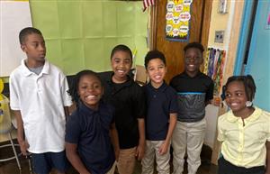  small group of students standing in front of puzzle