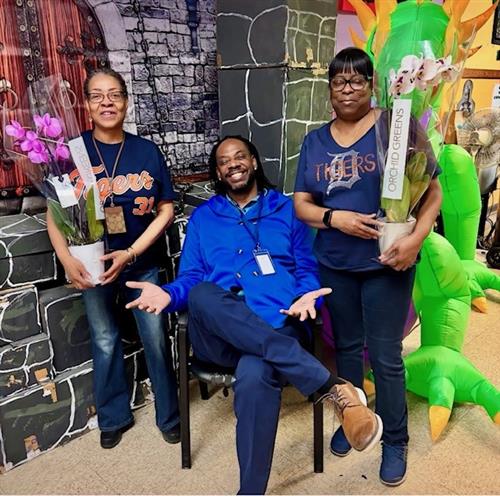  man sitting on chair next to two women