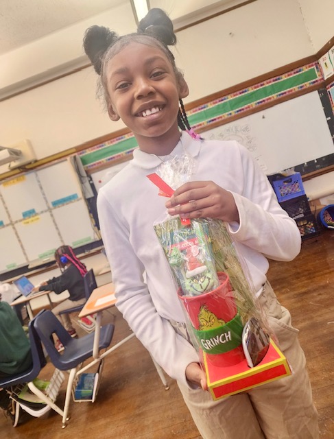  student holding a grinch award