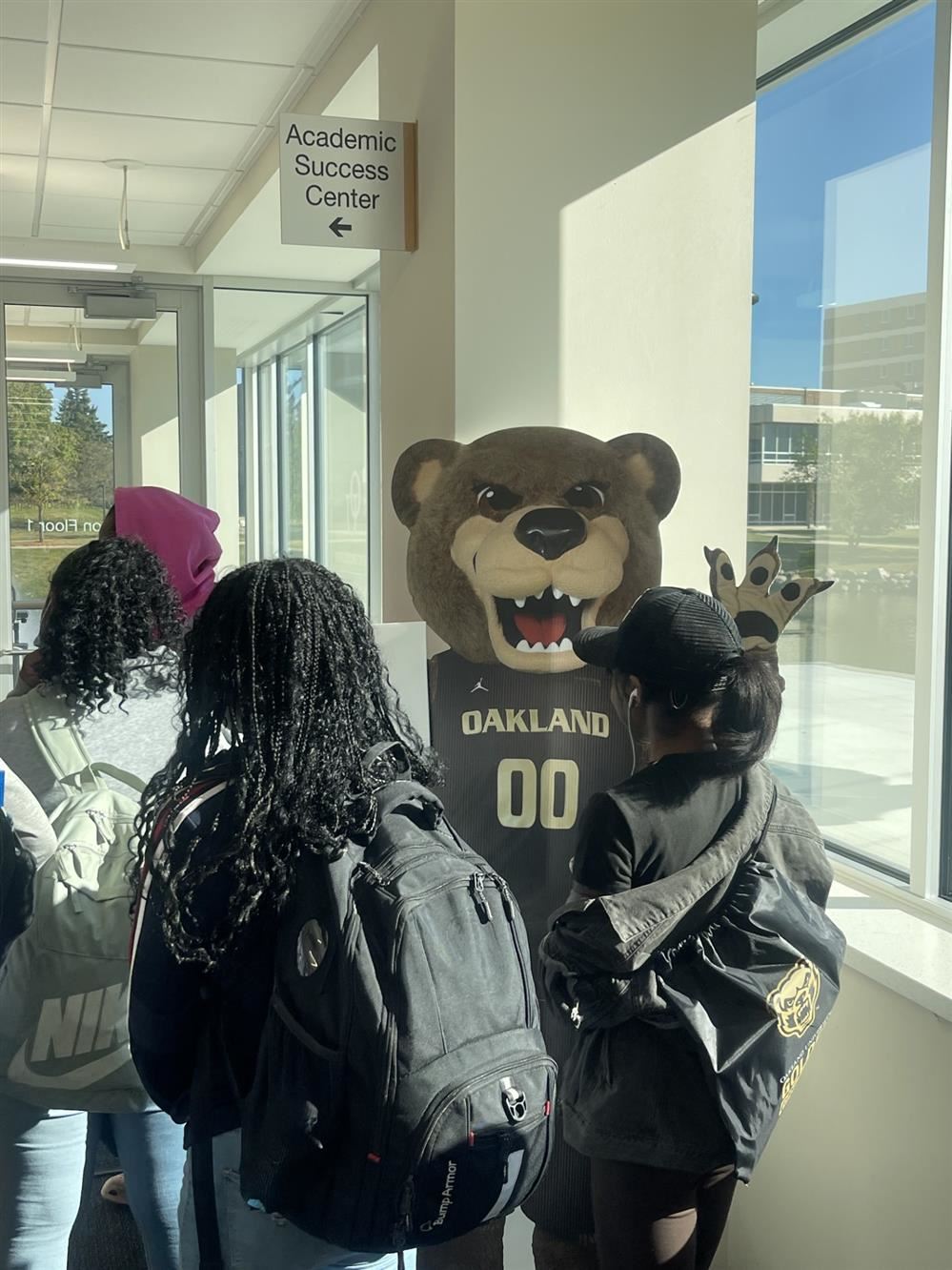  students in front of mascot