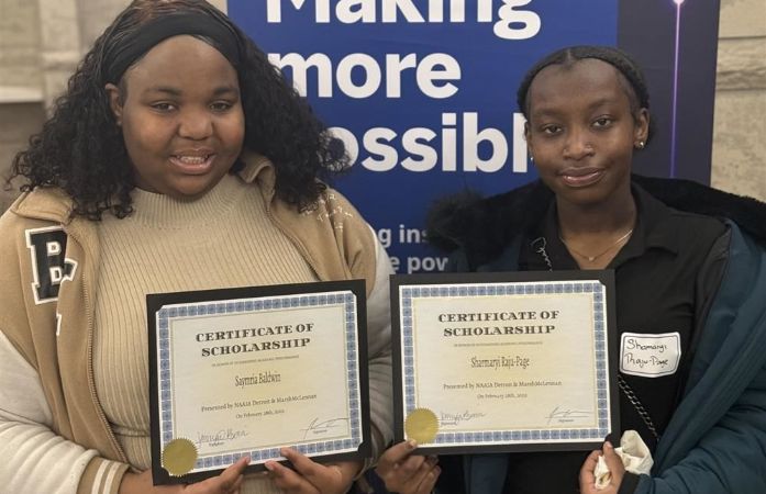   students smiling and holding scholarship recognitions