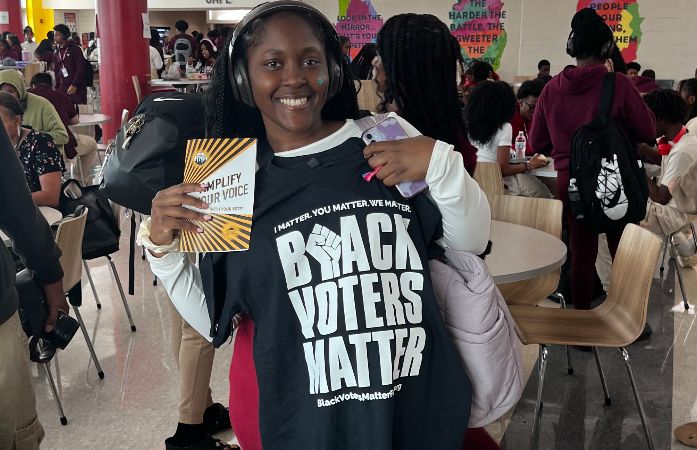  student holding a Black Voters Matter tshirt