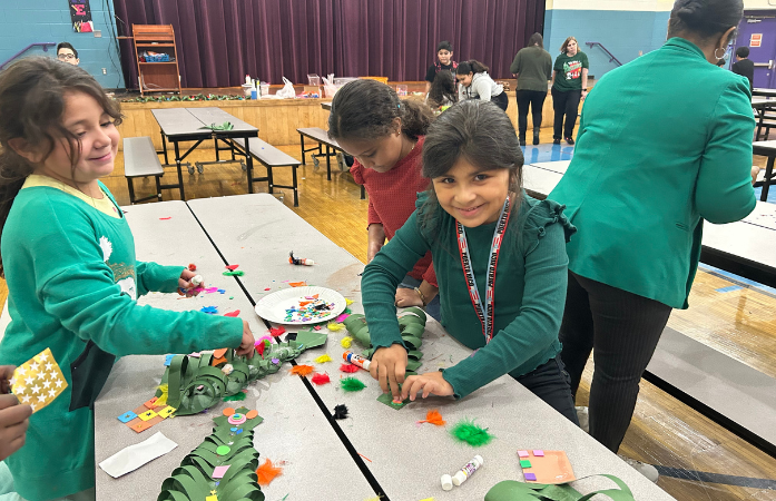  3 girls decorating their paper christmas tree 