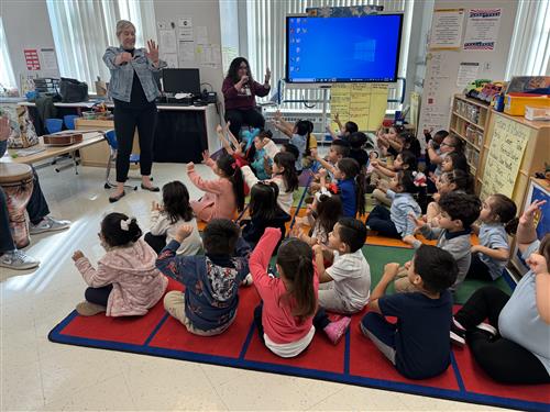 children sitting on the floor two ladies 