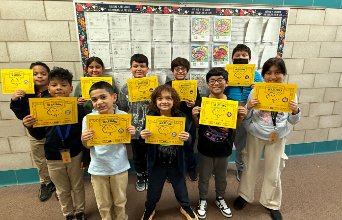  10 students pose in the hallway holding certificates 