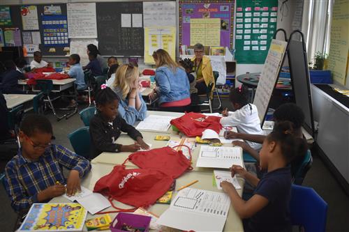 Volunteers from Quicken Loans work with first grade students 