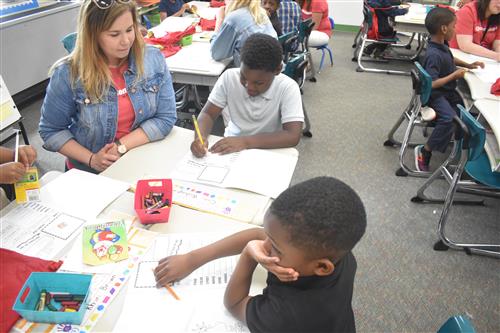 Students and teacher sitting at at a table.