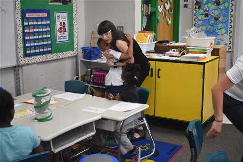 First grade student hugs tutor from Tutormate 