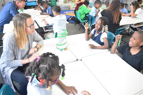 Volunteer from Lear talks with first grade students. 
