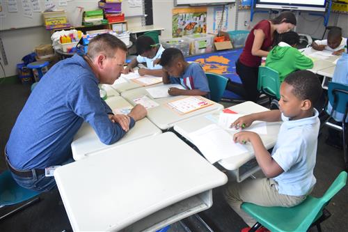 Students in first grade work side by side with Lear volunteer from Tutormate 