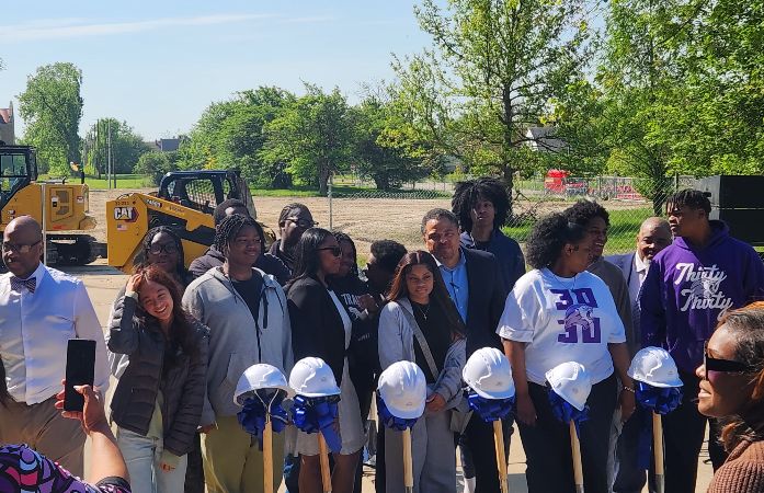  Students standing behind shovels and hard hats