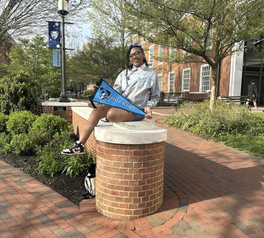  KrisTiana Dove siting holding a Hopkins Flag