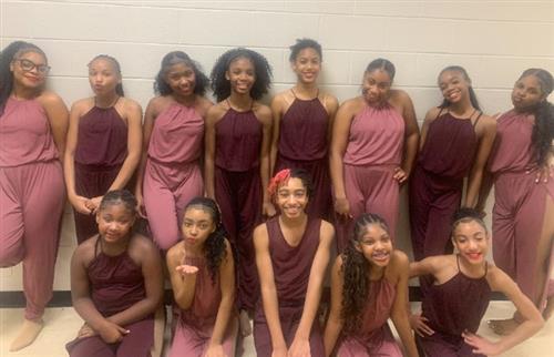  13 dancers posing in costume prior to their performance