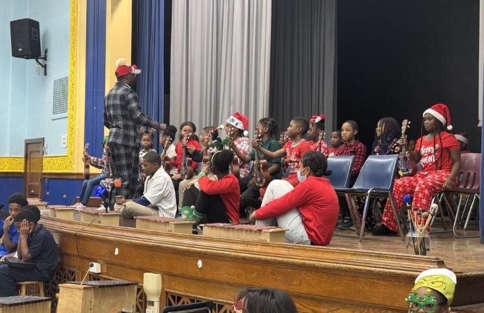   Music Teacher leading his students in program