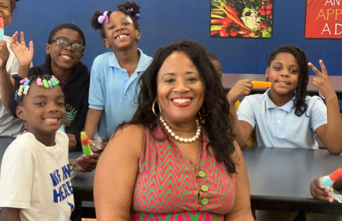 School counselor smiling with students with popsicles in their hands