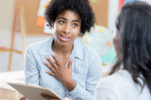  Image of a teacher talking to a parent and student.