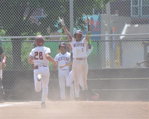 Western baseball players celebrating a run as #28 crosses home plate